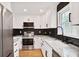 Bright kitchen features white cabinets, stainless steel appliances, black backsplash and granite countertops at 136 Peachtree Memorial Nw Dr # Nj2, Atlanta, GA 30309