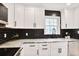 Bright kitchen features white cabinets, stainless steel appliances, black backsplash and granite countertops at 136 Peachtree Memorial Nw Dr # Nj2, Atlanta, GA 30309