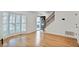 Sunlit living room with wood floors, large bay window with shutters, and modern staircase at 136 Peachtree Memorial Nw Dr # Nj2, Atlanta, GA 30309