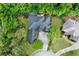 Aerial view of a home with a dark roof, surrounded by lush greenery and a well-maintained lawn at 1477 Edenham Ln, Cumming, GA 30041