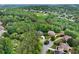 High-angle view of houses nestled among dense green trees, with a glimpse of a golf course in the background at 1477 Edenham Ln, Cumming, GA 30041