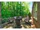 Back deck with a stone patio, a fire pit, wood railings, wood chairs, and a wooded view at 1477 Edenham Ln, Cumming, GA 30041