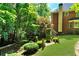 Green backyard featuring stone stairs, a wood fence, manicured lawn, and lush trees at 1477 Edenham Ln, Cumming, GA 30041