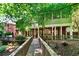 Exterior showcasing a backyard with a walkway leading to a covered patio, complemented by green trees at 1477 Edenham Ln, Cumming, GA 30041