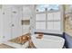 Bathroom with standalone tub, glass shower, tiled walls and floors and large window at 1477 Edenham Ln, Cumming, GA 30041