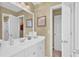 A bright, white bathroom vanity with chrome hardware and a door that leads into the toilet and shower area at 1477 Edenham Ln, Cumming, GA 30041
