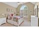 Charming bedroom features an arched window, neutral carpeting and is decorated in light, neutral colors at 1477 Edenham Ln, Cumming, GA 30041