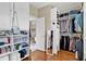 Custom closet with built-in shelving, cabinets and storage for accessories, and an attached bathroom at 1477 Edenham Ln, Cumming, GA 30041