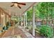 Covered patio featuring a wood picnic table, stone flooring, and beautiful wooded view at 1477 Edenham Ln, Cumming, GA 30041
