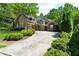 View of a well-maintained home with a manicured lawn and a spacious driveway, lush green trees surrounding at 1477 Edenham Ln, Cumming, GA 30041
