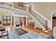 Spacious living room featuring hardwood floors, staircase and seamless transition to other rooms at 1477 Edenham Ln, Cumming, GA 30041
