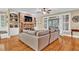 Spacious living room with stone fireplace, built-in shelves, ceiling fan, and access to the screened in porch at 1477 Edenham Ln, Cumming, GA 30041