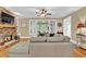 Comfortable living room featuring a stone fireplace, a large ceiling fan, and doors to the porch at 1477 Edenham Ln, Cumming, GA 30041