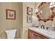 Powder room with vanity, decorative mirror and lighting at 1477 Edenham Ln, Cumming, GA 30041