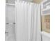 A shower stall with glass doors and white curtains in a bathroom with neutral colored walls at 1477 Edenham Ln, Cumming, GA 30041