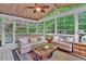 Bright sunroom with vaulted ceiling, many windows and comfortable seating to take in the surrounding wooded scenery at 1477 Edenham Ln, Cumming, GA 30041
