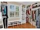 Walk-in closet featuring custom shelving, storage, hardwood floors and a window at 1477 Edenham Ln, Cumming, GA 30041