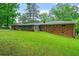 Expansive backyard featuring a brick home with a screened-in porch and lush green lawn at 1728 N Holly Ne Ln, Atlanta, GA 30329