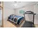 Cozy bedroom featuring a bed, ceiling fan, window, and adjacent work out equipment at 1728 N Holly Ne Ln, Atlanta, GA 30329