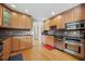 Well-lit kitchen features wooden cabinets, stainless steel appliances, black countertop, and hardwood floors at 1728 N Holly Ne Ln, Atlanta, GA 30329