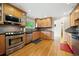 Kitchen features stainless steel appliances, wooden cabinets, tile backsplash, hardwood floors, and natural light at 1728 N Holly Ne Ln, Atlanta, GA 30329
