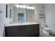 Bright bathroom with double sinks, modern vanity, large mirror, tiled floors and a white toilet at 22 Moda Ln, Atlanta, GA 30316