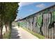 Path bordered by lush trees and a vibrant graffiti-covered wall in an urban setting at 22 Moda Ln, Atlanta, GA 30316