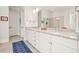 Bathroom with double sinks, granite counters, white cabinets, blue geometric rug, and a glass shower at 2861 Digna Ct, Acworth, GA 30101
