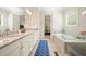 Well lit bathroom with double sinks, walk in shower, soaking tub, and a geometric blue rug at 2861 Digna Ct, Acworth, GA 30101