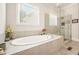 Bathroom showcasing a soaking tub with a tiled surround and a frameless glass shower at 2861 Digna Ct, Acworth, GA 30101