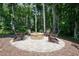 Inviting outdoor stone fire pit area with seating, perfect for gatherings in a private, wooded setting at 2861 Digna Ct, Acworth, GA 30101