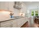 Kitchen features white cabinetry, stainless vent hood, granite countertops, and stainless gas range at 2861 Digna Ct, Acworth, GA 30101