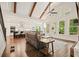 Open-concept living room with hardwood floors, beamed ceilings, and large windows overlooking wooded backyard at 2861 Digna Ct, Acworth, GA 30101