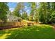 Spacious, green backyard with wooden fence, bridge, and a house with a deck, perfect for outdoor relaxation and entertaining at 1377 Oak Grove Dr, Decatur, GA 30033