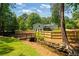Large fenced backyard features mature trees, a wooden bridge, a stream, and a spacious deck, perfect for outdoor living at 1377 Oak Grove Dr, Decatur, GA 30033