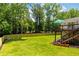 Spacious backyard with lush green lawn, a stained wood fence and deck with stairs at 1377 Oak Grove Dr, Decatur, GA 30033