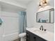 Modern bathroom features a black vanity, framed mirror, and a shower with a decorative curtain at 1377 Oak Grove Dr, Decatur, GA 30033