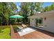 A wooden deck featuring modern chairs and an umbrella, next to a brick house and green lawn at 1377 Oak Grove Dr, Decatur, GA 30033