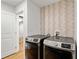 Laundry room with modern appliances, decorative wallpaper, and an access door at 1377 Oak Grove Dr, Decatur, GA 30033