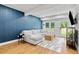 Bright living room with a modern sectional sofa, blue accent wall, and outdoor access at 1377 Oak Grove Dr, Decatur, GA 30033