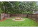 Backyard with a circular fire pit, lush green grass, and a wood fence at 194 Locust Nw St, Marietta, GA 30064