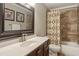 Bathroom with a marble countertop, framed mirror, tile shower, and patterned shower curtain at 194 Locust Nw St, Marietta, GA 30064