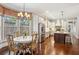 Eat-in kitchen boasts a chandelier, stainless steel appliances, custom cabinets, and hardwood flooring at 194 Locust Nw St, Marietta, GA 30064