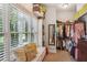Well-organized walk-in closet with shelving, hanging racks, full-length mirror and bench seat under a sunlit window at 194 Locust Nw St, Marietta, GA 30064