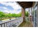 View from balcony with brick pillar overlooking parking lot, lush green trees, and blue sky at 1955 Nocturne Dr # 3206, Alpharetta, GA 30009