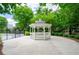 Community gazebo surrounded by lush landscaping with gated pool area in the background at 1955 Nocturne Dr # 3206, Alpharetta, GA 30009