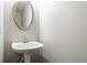 This powder room features a pedestal sink and oval mirror at 1955 Nocturne Dr # 3206, Alpharetta, GA 30009