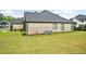 Large backyard showcasing the home's brick exterior, manicured lawn, and well-maintained landscaping at 3991 Perry Pass, Lithonia, GA 30038