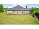 Spacious backyard featuring lush green lawn, mature trees, and a view of the home's exterior at 3991 Perry Pass, Lithonia, GA 30038