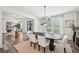 Well-lit dining area with a modern light fixture, dining table set, and view to the green outdoors at 3991 Perry Pass, Lithonia, GA 30038